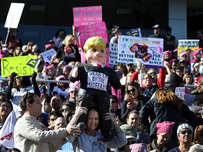 Participants, one with a U.S. President Donald Trump figure, stand strong and applaud with their signs during the Women's March Anniversary "Power To The Polls" event, Jan. 21, 2018 at Sam Boyd Stadium in Las Vegas, Nevada.
(L.E. BASKOW/AFP/Getty Images