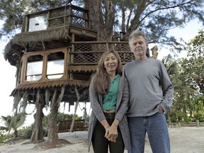 Lynn Tran and her husband Richard Hazen pose near their Australian pine treehouse Thursday, Jan. 4, 2018, in Holmes Beach, Fla. The couple is hoping the U.S. Supreme Court will hear their case after city and state officials ordered the treehouse removed.
