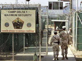 In this June 27, 2006 file photo, reviewed by a U.S. Department of Defense official, U.S. military guards walk within Camp Delta military-run prison, at the Guantanamo Bay U.S. Naval Base, Cuba. (AP Photo/Brennan Linsley, File)