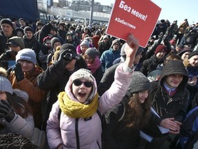 Demonstrators shout slogans holding a poster which reads "Elections without me! Strike." during a rally in Vladivostok, Russia, Sunday, Jan. 28, 2018. Opposition politician Alexey Navalny calls for nationwide protests following Russia's Central Election Commission's decision to ban his presidential candidacy.