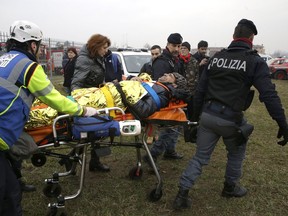 An injured passenger is assisted after a train derailed at the station of Pioltello Limito, on the outskirts of Milan, Italy, Thursday, Jan. 25, 2018.