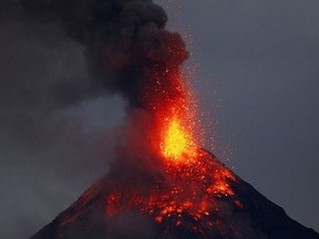 Mayon volcano spews red-hot lava in another eruption as seen from Legazpi city, Albay province, roughly 200 miles (340 kilometers) southeast of Manila, Philippines, Tuesday, Jan. 23, 2018. Mayon has spewed fountains of red-hot lava and massive ash plumes anew in a dazzling but increasingly dangerous eruption that has sent 56,000 villagers fleeing to evacuation centers.