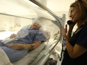 A nurse looks on as Karen (L) receives treatment at the Rouge Valley Hyperbaric Medical Centre. (JACK BOLAND, Toronto Sun)