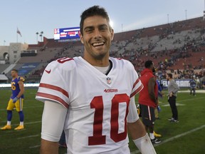 In this Dec. 31, 2017, file photo, San Francisco 49ers quarterback Jimmy Garoppolo smiles as he walks off the field after the team's 34-13 win over the Los Angeles Rams in Los Angeles.