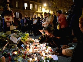 FILES: Members of the public view candles and tributes left opposite the main entrance of Bataclan concert hall as French police lift the cordon following Fridays terrorist attacks on November 16, 2015 in Paris, France. A Europe-wide one-minute silence was held in honour of at least 129 people who were killed in a series of terror attacks in the French capital.