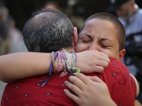 Emma Gonzalez hugs her father Jose Gonzalez as they join other people after a school shooting that killed 17 to protest against guns on the steps of the Broward County Federal courthouse on February 17, 2018 in Fort Lauderdale, Florida. Earlier this week former student Nikolas Cruz opened fire with a AR-15 rifle at the Marjory Stoneman Douglas High School killing 17 people.