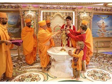 In this photograph released by the Swaminarayan Akshardham Temple on February 19, 2018, Canadian Prime Minister Justin Trudeau (4R) and his sons Xavier (2R) and Hadrien (R) take part in a ritual during a visit to the temple in the Indian town of Gandhinagar.