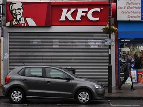 Pedestrians pass outside a closed KFC fast food store in south London on February 19, 2018. US fast food chain KFC said on February 19 it had been forced to close many restaurants in Britain because of a new supplier failing to deliver chicken in time, generating some tongue-in-cheek outrage on Twitter.