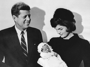 This December 10, 1960, file photo shows John F. Kennedy and his wife Jacqueline holding their son John during the christening ceremony at the chapel of Georgetown University in Washington, DC.