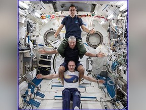 This image provided by NASA on Feb. 25, 2018, shows from bottom to top: Russia’s Alexander Misurkin, NASA’s Mark Vande Hei, middle, and NASA’s Joe Acaba posing for a photograph at the International Space Station.  (NASA via AP)
