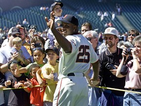In this April 13, 2002, file photo, San Francisco Giants' Barry Bonds waves and poses for fans during the annual on-field photo day before the Giants' game against the Milwaukee Brewers in San Francisco. (AP Photo/Eric Risberg, File)