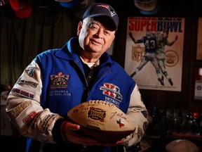 In this Jan. 25, 2018 photo Donald Crisman poses with memorabilia from the 51 Super Bowls he has attended so far, at his home in Kennebunk, Maine