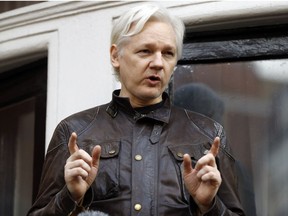 In this May 19, 2017 file photo, WikiLeaks founder Julian Assange gestures to supporters outside the Ecuadorian embassy in London, where he has been in self imposed exile since 2012. A British judge on Tuesday Feb. 13, 20-18 is scheduled to quash or uphold an arrest warrant for WikiLeaks founder Julian Assange, who has spent more than five years inside Ecuador's London embassy. Assange's lawyers argue that it's no longer in the public interest to arrest him for jumping bail in 2012. Assange was wanted in Sweden for a rape investigation when he sought protection in the Ecuadorean embassy. Swedish prosecutors dropped the case last year, but the British warrant still stands. (AP Photo/Frank Augstein, FILE)