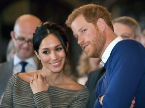 In this Thursday Jan. 18, 2018 file photo, Britain's Prince Harry talks to Meghan Markle as they watch a dance performance by Jukebox Collective in the banqueting hall during a visit to Cardiff Castle, Wales.