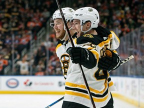 Boston Bruins' David Pastrnak and Matt Grzelcyk celebrate a goal against the Edmonton Oilers on Feb. 20, 2018