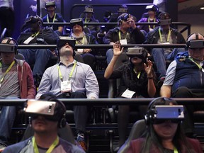 People look through Samsung Gear VR virtual reality goggles at the Samsung booth during CES International, Tuesday, Jan. 9, 2018, in Las Vegas.  THE CANADIAN PRESS/AP/John Locher