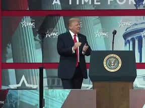 In this screenshot, President Donald Trump enters the stage to deliver a speech at the Conservative Political Action Conference in Oxon Hill, Md. on Feb. 23, 2018.