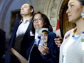Debbie Baptiste holds up a photo of her son Colten Boushie, as the family spoke to reporters in the Foyer of the House of Commons after a day of meetings on Parliament Hill, in Ottawa on Tuesday, Feb. 13, 2018.