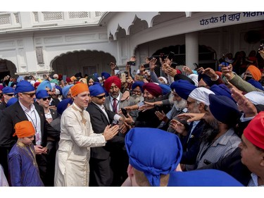 Canadian Prime Minister Justin Trudeau, in orange headgear, greets members of Sikh community during his visit to Golden Temple, in Amritsar, India, Wednesday, Feb. 21, 2018.