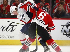 Washington Capitals right wing T.J. Oshie (77) battles Chicago Blackhawks defenseman Michal Kempny (6) for the puck during the first period of an NHL hockey game Saturday, Feb. 17, 2018, in Chicago.
