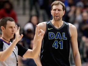 Referee Mark Lindsay gestures to the officials table as Dallas Mavericks forward Dirk Nowitzki of Germany watches Lindsay charge him with a foul during an NBA game on Feb. 13, 2018