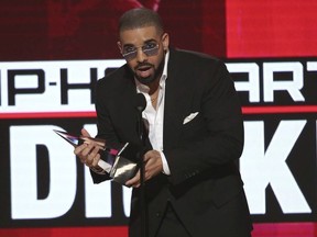 In this Nov. 20, 2016, file photo, Drake accepts the award for favorite artist - rap/hip-hop at the American Music Awards at the Microsoft Theater in Los Angeles. Drake made a surprise stop at a Florida homeless shelter for women and children, bringing a $50,000 check and toys and games for the kids. The Grammy-award winner stopped at Miami's Lotus Village on Tuesday, Feb. 6, 2018, to support families who moved into the nonprofit's new shelter one week ago. Drake passed out $150 Target gift cards for the female residents.