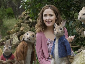 This image released by Columbia Pictures shows Rose Byrne with characters, from left, Mopsy, voiced by Elizabeth Debicki, Flopsy, voiced by Margot Robbie, Benjamin, voiced by Colin Moody, Peter Rabbit, voiced by James Corden and Cottontail, voiced by Daisy Ridley in a scene from "Peter Rabbit." (Columbia Pictures/Sony via AP)