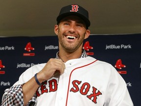 Boston Red Sox baseball player J.D. Martinez smiles as he buttons up his jersey during an introductory news conference, Monday, Feb. 26, 2018, in Fort Myers, Fla.
