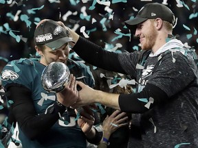 Philadelphia Eagles quarterback Carson Wentz, right, hands the Vince Lombardi trophy to Nick Foles after winning Super Bowl LII Sunday, Feb. 4, 2018, in Minneapolis. (AP Photo/Frank Franklin II)