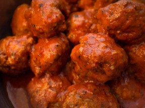 This stock photo shows a closeup of homemade Italian meatballs in red tomato sauce.