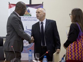 Oxfam International Regional Director for Latin America, Simon Ticehurst (centre) shakes hands with Haiti's Minister of Planning and External Cooperation Aviol Fleurant after a meeting in Port-au-Prince, Haiti, Thursday, Feb. 22, 2018.