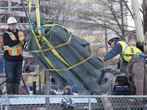 Contractors remove the statue of Edward Cornwallis, a controversial historical figure, in a city park in Halifax on Wednesday, Jan. 31, 2018.
