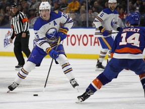 Sabres forward Jack Eichel (left) skates up ice as  Islanders' Thomas Hickey (14) defends during NHL action in Buffalo, N.Y., on Thursday, Feb. 8, 2018.