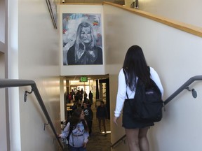 In this Tuesday, Jan. 30, 2018 photo provided by Sophia Muys, students pass under one of James Franco's paintings displayed above a stairwell in the Media Arts Center at Palo Alto High School in Palo Alto, Calif.