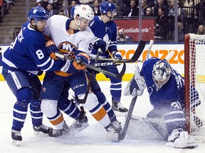 Toronto Maple Leafs goaltender Frederik Andersen (right) covers the puck in front of New York Islanders' Adam Pelech (centre) and Maple Leafs' Connor Carrick in Toronto, on Thursday, February 22, 2018. (THE CANADIAN PRESS/Chris Young)