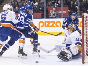New York Islanders goaltender Jaroslav Halak makes a save in front of Toronto Maple Leafs' William Nylander (centre) as Islanders defenceman Ryan Pulock closes in during overtime NHL hockey action in Toronto, on Thursday, February 22, 2018.THE CANADIAN PRESS/Chris Young