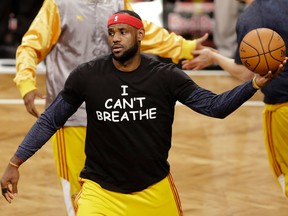 In this Dec. 8, 2014 file photo, Cleveland Cavaliers' LeBron James wears a T-shirt reading "I Can't Breathe," protesting the death of Eric Garner, during warms up before an NBA basketball game against the Brooklyn Nets in New York