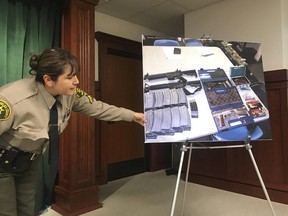 Deputy Lisa Jansen displays photos of weapons and ammo at a news conference in Los Angeles on Wednesday, Feb. 21, 2018.