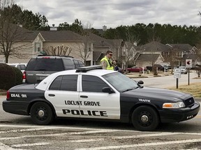 Authorities investigate the scene where multiple law enforcement officers have been shot and a suspect is dead south of Atlanta, Friday, Feb. 9, 2018, in Locust Grove, Ga.