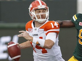 B.C. Lions quarterback Travis Lulay (14) looks to make the throw as Edmonton Eskimos defensive end Kwaku Boateng (93) gives chase in Edmonton on Friday, July 28, 2017. (THE CANADIAN PRESS/Jason Franson)