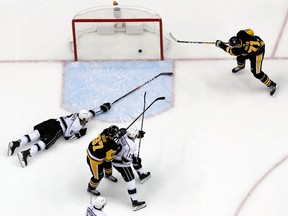 Los Angeles Kings' Drew Doughty reaches but can't stop Pittsburgh Penguins' Evgeni Malkin from putting a pass from Sidney Crosby into the net on Feb. 15, 2018