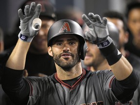 Arizona Diamondbacks' J.D. Martinez gestures toward the camera as he stands in the dugout after hitting his fourth home run of the game against the Los Angeles Dodgers, Monday, Sept. 4, 2017, in Los Angeles. (AP Photo/Mark J. Terrill)