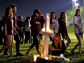 Students walk past one of 17 crosses after a candlelight vigil for the victims of the Wednesday shooting at Marjory Stoneman Douglas High School, in Parkland, Fla., Thursday, Feb. 15, 2018.  (AP Photo/Gerald Herbert)