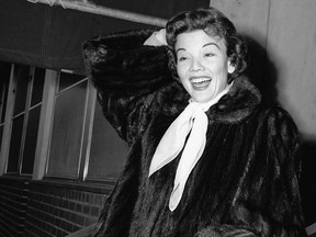 In this Dec. 10, 1955 file photo, actress Nanette Fabray poses as she leaves Mt. Sinai hospital in New York. Fabray, the vivacious, award-winning star of the stage, film and television, has died at age 97. Fabray's son, Dr. Jamie MacDougall, tells The Associated Press his mother died Thursday, Feb. 22, 2018, at her home in Palos Verdes Estates, Calif. (AP Photo/File)