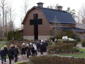 Pall bearers carry the casket carrying the body of Billy Graham as family member follow behind to the Billy Graham Library in Charlotte, N.C., Saturday, Feb. 24, 2018.