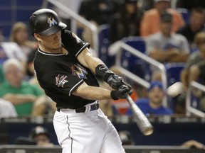 In this June 24, 2017, file photo, Miami Marlins' J.T. Realmuto hits a three-run home run against the Chicago Cubs in Miami.