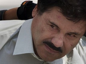 In this Feb. 22, 2014 file photo, Joaquin "El Chapo" Guzman is escorted to a helicopter in handcuffs by Mexican navy marines at a navy hanger in Mexico City. (AP Photo/Eduardo Verdugo, File)