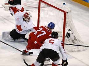 Martin Ruzicka (27), of the Czech Republic, scores a goal past goalie Kevin Poulin (31), of Canada, during the first period of the men's bronze medal hockey game at the 2018 Winter Olympics in Gangneung, South Korea, Saturday, Feb. 24, 2018.