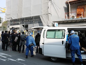 Hyogo prefectural police (R) are pictured at the scene as they investigate an apartment (L) where a decapitated head was found in Osaka on February 25, 2018. (JIJI PRESS/AFP/Getty Images)
