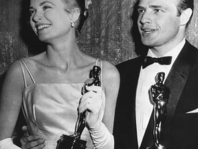 FILE - In this March 31, 1955 file photo, Grace Kelly, left, and Marlon Brando, hold their best actress and actor Oscars in Los Angeles. Kelly's icy green satin gown was designed by Edith Head.  (AP Photo, File)